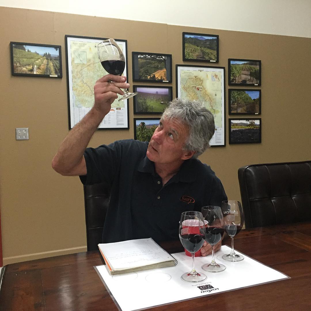 Chris Loxton evaluating a glass of red wine in the tasting room